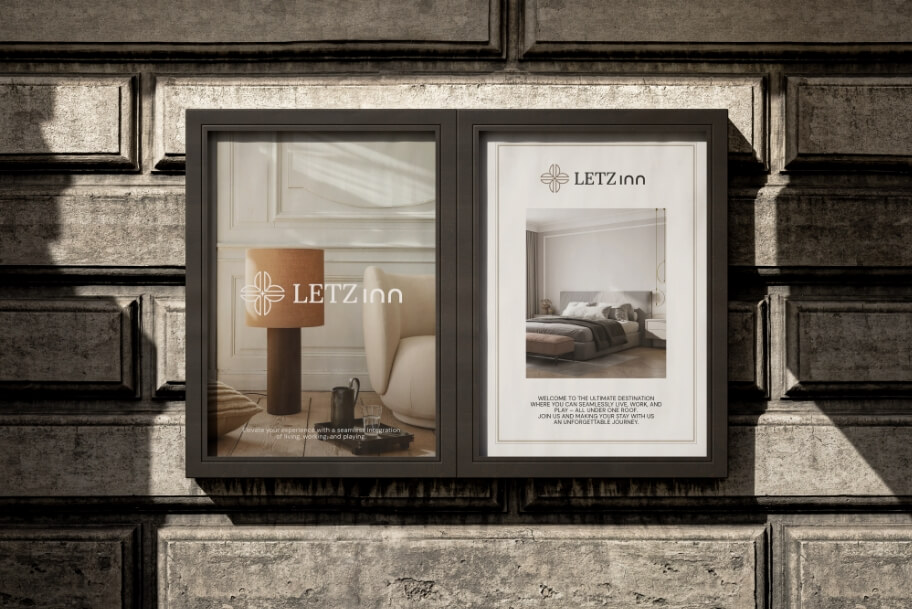 Two framed LETZ inn advertisements in a stone facade window, one showing a living room with a lamp and chair, the other a bedroom interior.