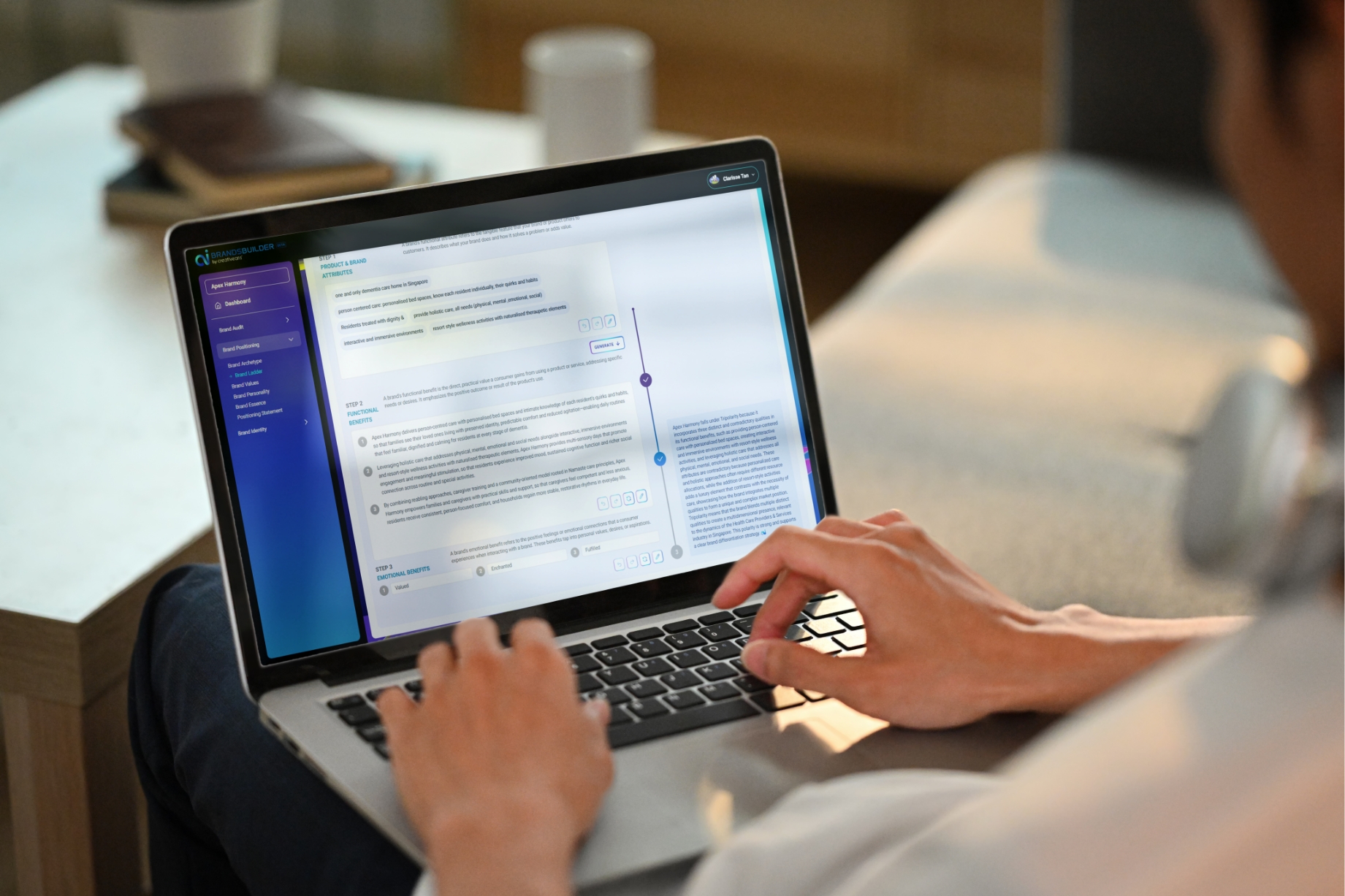 Person typing on a laptop displaying a multi-section document or design software with a blue sidebar on the left.
