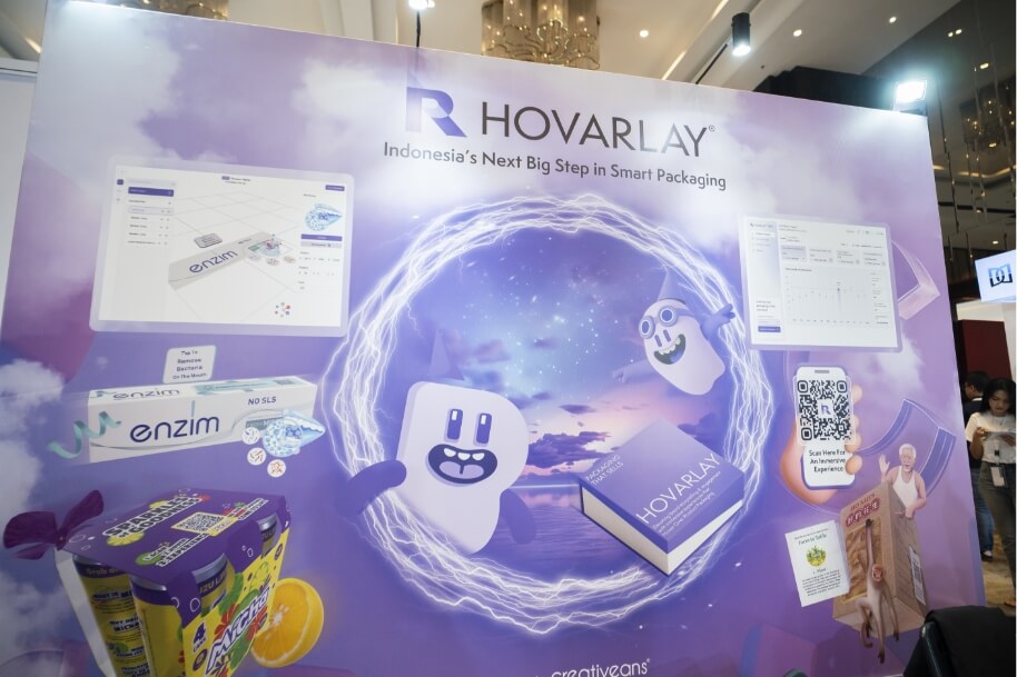 Hovarlay trade show booth with a purple backdrop, displaying packaging products, QR code, and product graphics centered in a glowing ring.