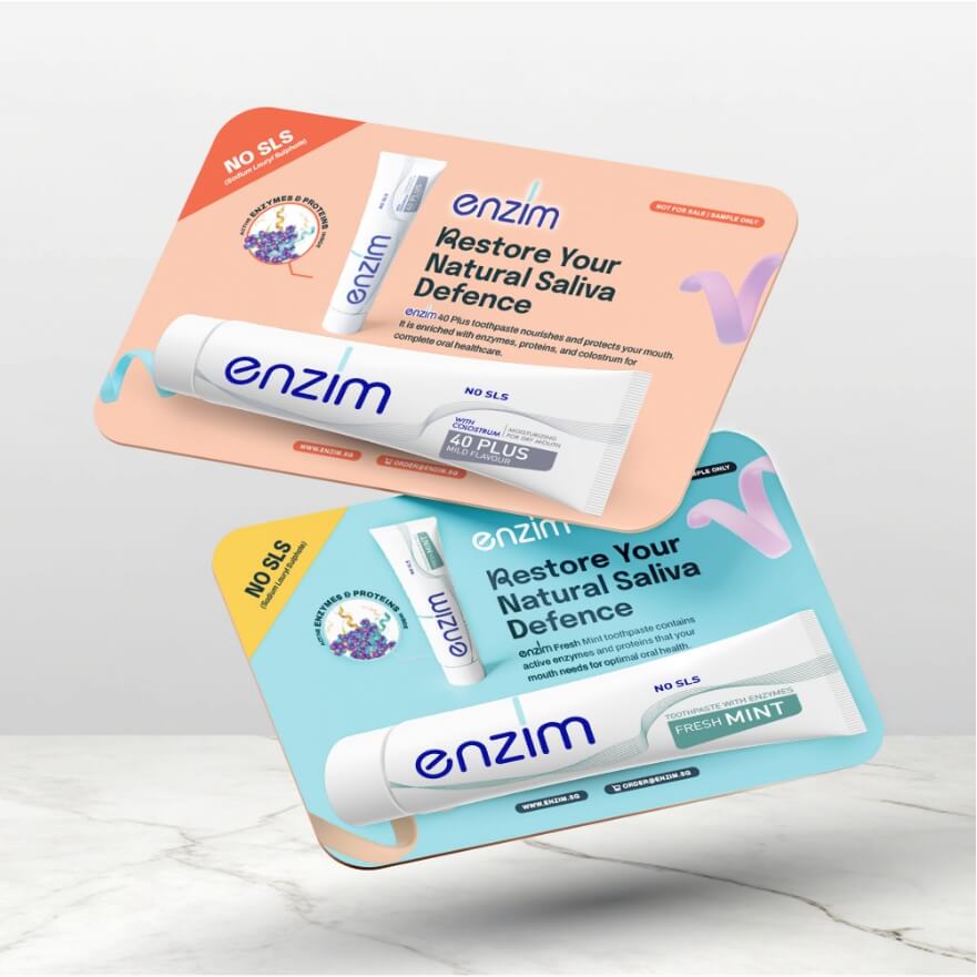Two Enzim toothpaste displays on peach and blue cards reading 'Restore Your Natural Saliva Defence'.